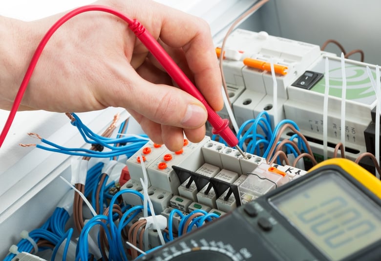 shutterstock_electrician uses multimeter probe at electrical switchgear cabinet