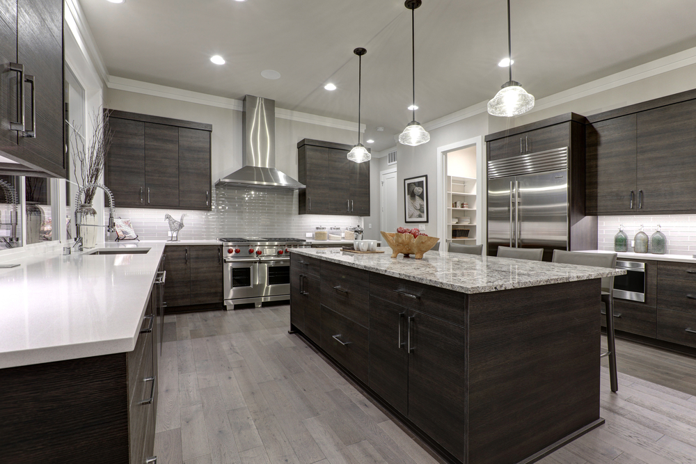 Modern gray kitchen features dark gray flat front cabinets paired with white quartz countertops and a glossy gray linear tile backsplash