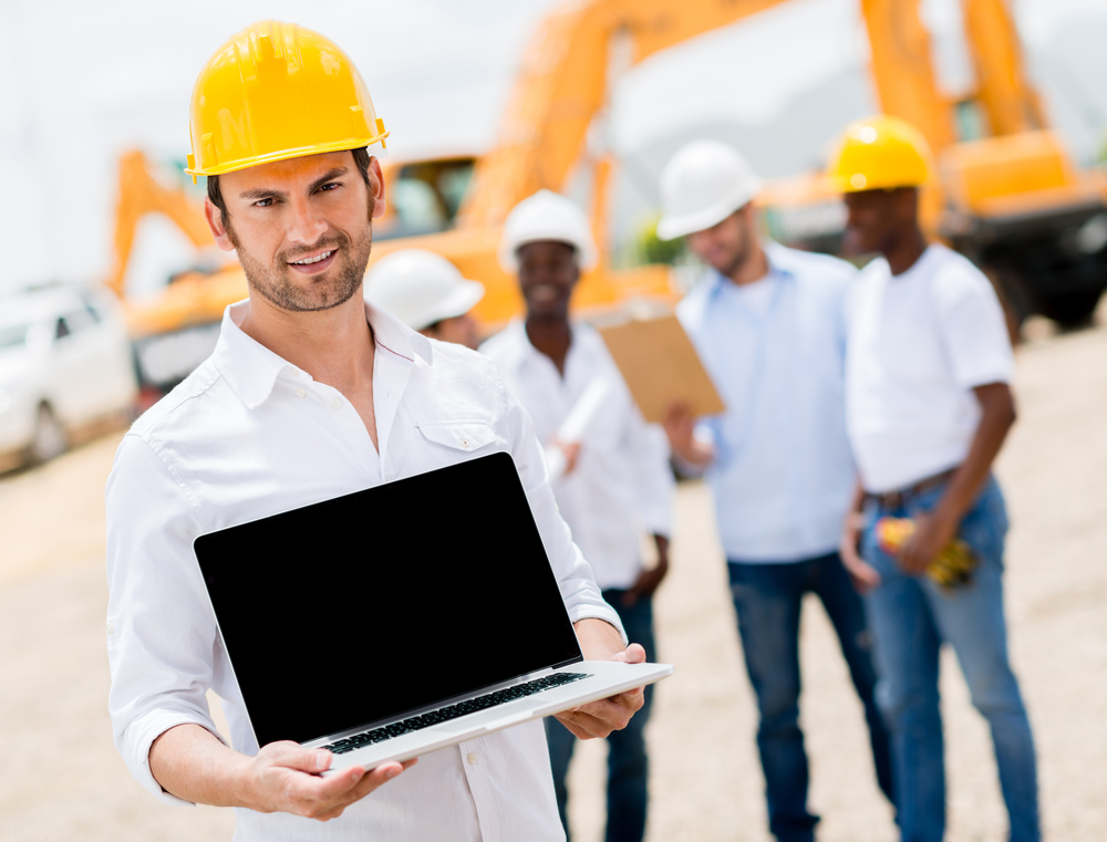 Male construction worker with a laptop computer