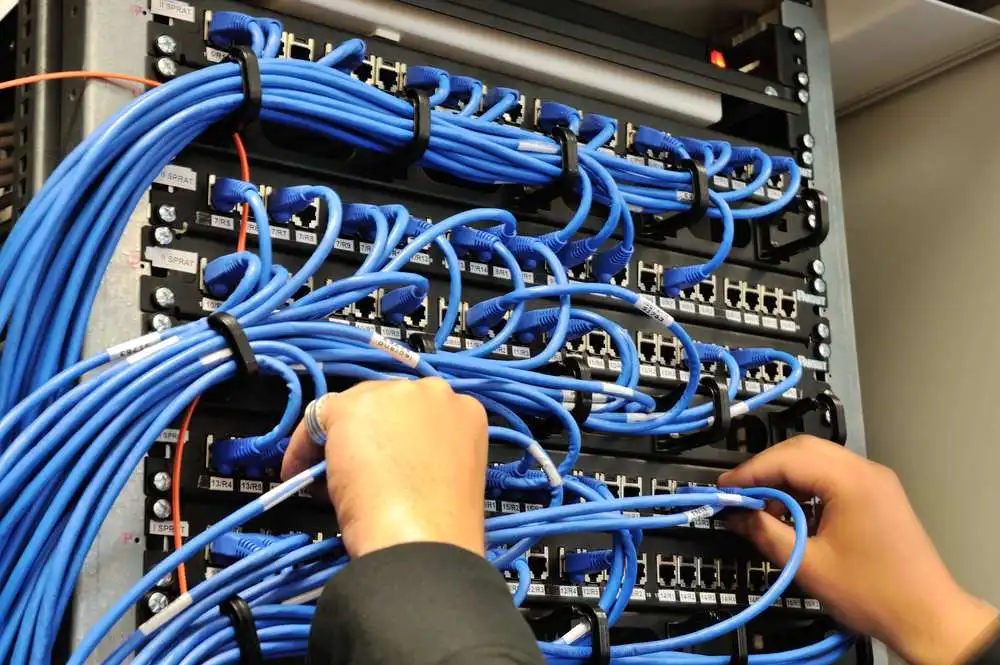 Man connecting network cables to switches